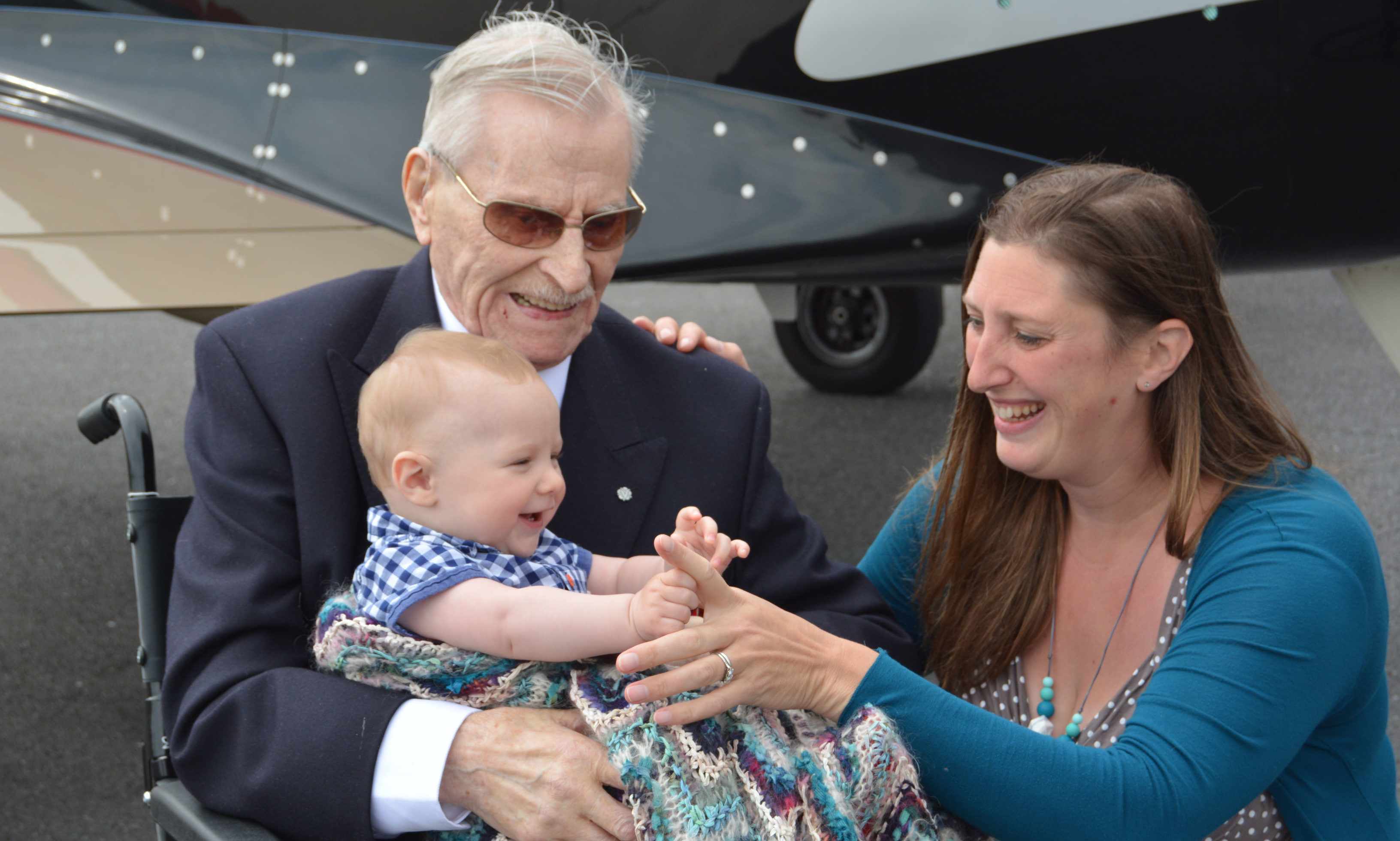 Flight Lieutenant Ernie Holmes DFC, meeting his great-grandson Henry for the first time at Coventry Airport, with Henry's mother Laura, as part of Project Propeller, an annual gathering of World War Two aircrew veterans.