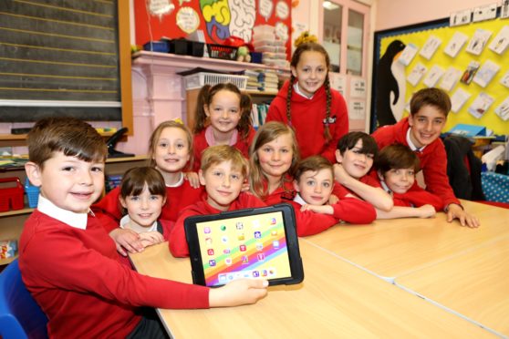 Nine-year-old Angus Gordon with the an IPad and the other members of the Liff Leaders"of Liff Primary School,