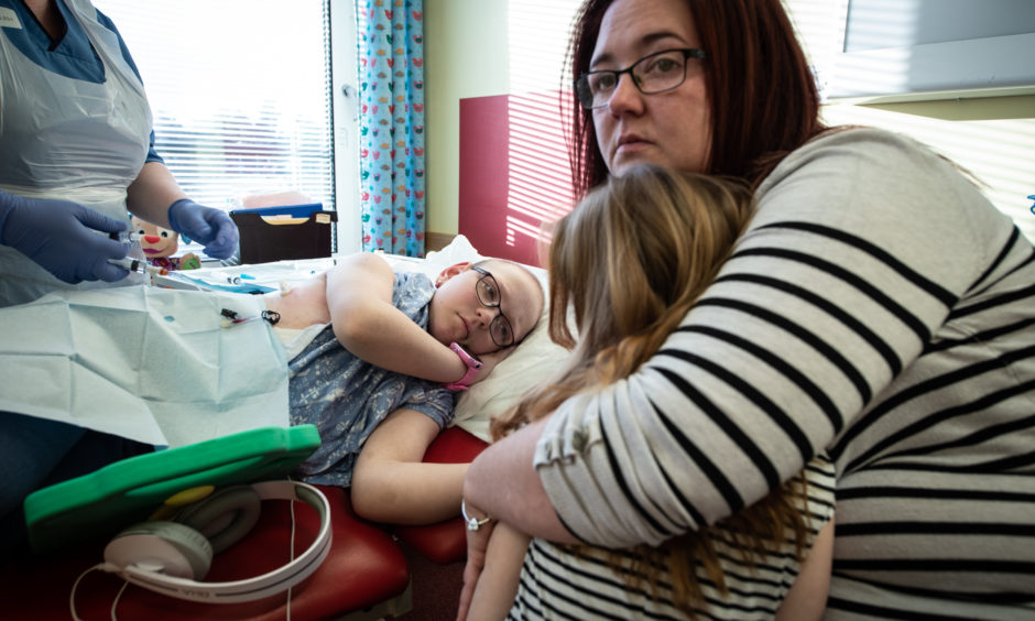 Vicky and Holly's sister look on as antibiotics are given.