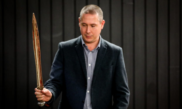 Warren Bailie with a reconstruction of a bronze age sword found at the site