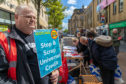 John Gillespie of Unite the Union holds a placard as people signed an Anti Universal Credit petition earlier this month.