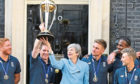 Prime Minister Theresa May with England cricket captain Eoin Morgan and members of the team with the trophy outside Downing Street, London, ahead of a reception hosted by the Prime Minister at Downing Street, London, to celebrate England's victory in the ICC World Cup.