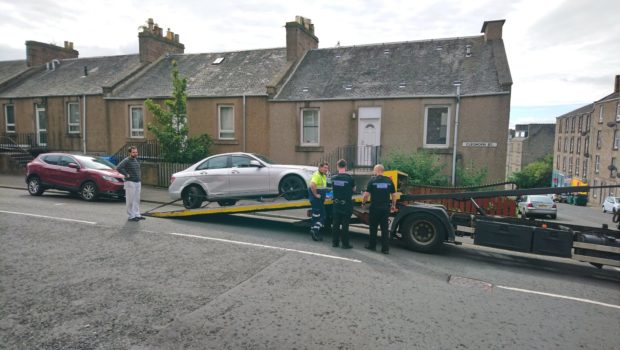 One of the cars being removed in Cleghorn Street.