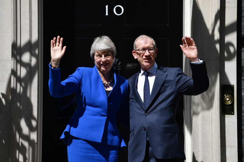 Theresa May waves to the world's media beside husband Philip May from outside 10 Downing Street