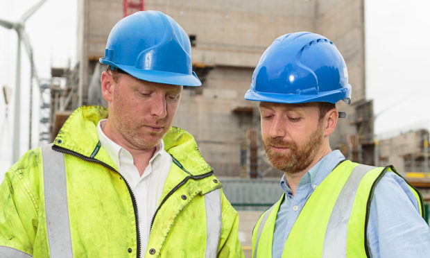 Caltech Lifts Managing Director Andrew Renwick (right) looks over the plans for the industrial lift installation with his brother, technical director Fraser Renwick.