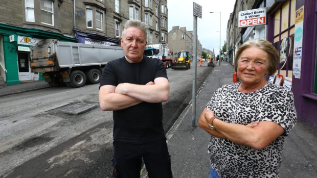 Abe McIntosh of Household Clearnces and Sandra Small of The Tanning Lounge beside the roadworks in Albert Street, Dundee.