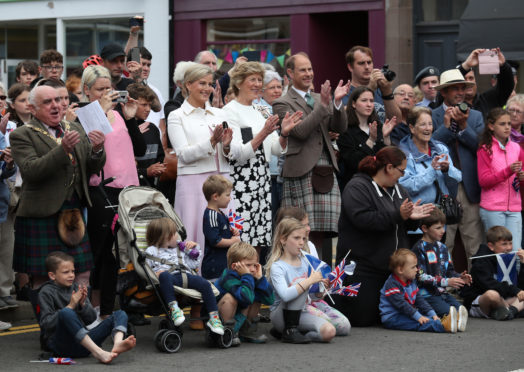 Lord Lieutenant Mrs Osborne applauds a Highland Dancing display with the new Earl and Countess of Forfar on their first visit to the town in July.