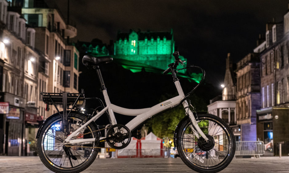 A bicycle in front of Edinburgh Castle, which is among the Scottish landmarks being turned green in support of a low-carbon campaign.