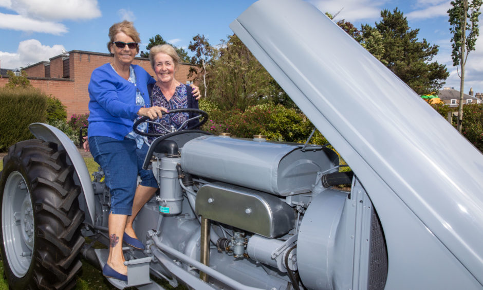 Marlene Caird and Linda Milne couldn't resist climbing onto the tractor for a photograph.