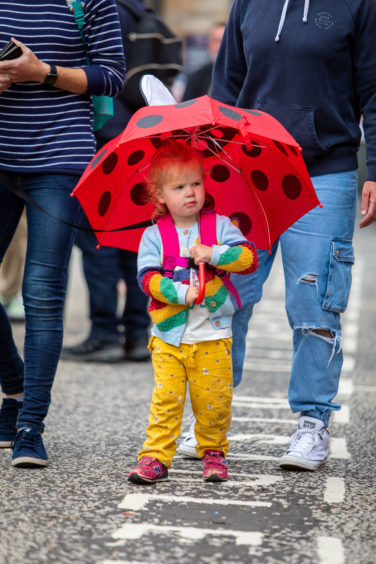 Bess Hamilton age 2 and a half from Glasgow walks through pride with her umbrella.