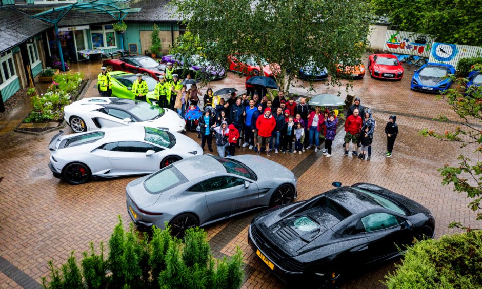 Supercar Owners, Rachel House staff, and service users with all the cars for the Supercar Fun Day at Rachel House in Kinross.