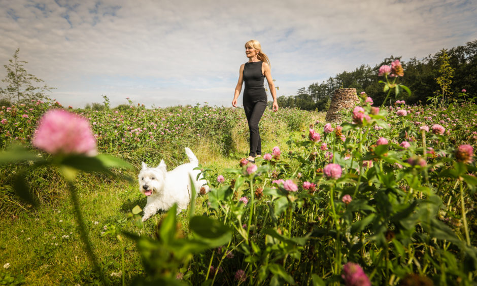 A green burial site in Angus has proved a popular final destination for a growing number of eco-conscious individuals.
More than 50 families have chosen an environmentally friendly send-off at the CairnBrae Natural Burial Ground following its opening 12 months ago.
Picture shows; Owner Alma Kettles with her dog Twiggy walking down the natural aisles of the burial ground. 
Picture by Mhairi Edwards / DCT Media