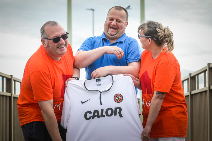 Dundee fan Scott Brown walks across Tay Road Bridge in a Dundee United top after losing a bet to United fans, Caroline and Stuart Main, that his side would not be relegated.