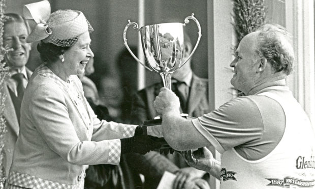 The Queen presents a trophy to Bill Anderson at the Braemar Gathering in 1987.