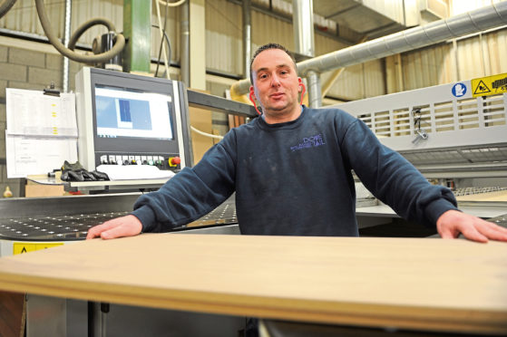 Steven Smith operating a beam saw at Dovetail Enterprises.