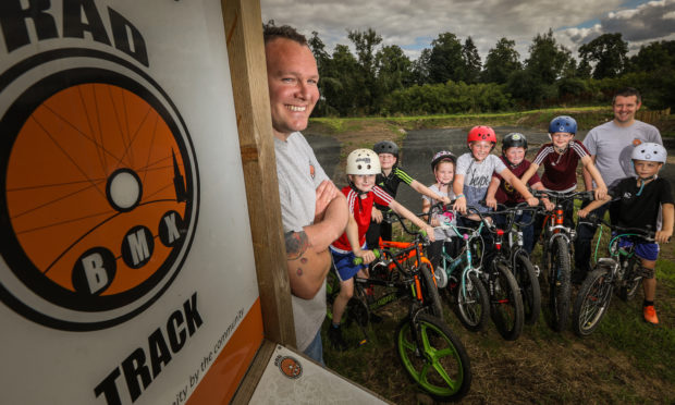 Chairman of the club Greg Morgan with Secretary Alastair Hoey and the local kids who love the new track.