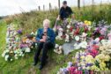 Moira Campbell and her dog, Rusty, with William Robertson, who tends to the grass and flowers at the roadside grave of 'Danny' near Loch Glow