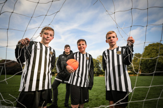 Ethan McWilliam, Alfie Stott and Kai McLellen with Chairman of Newtyle United, John Robertson and the damaged nets.