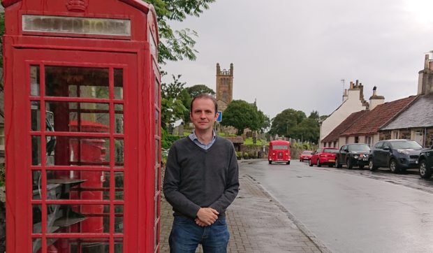 Stephen Gethins outside the phone box in Kilconquhar.