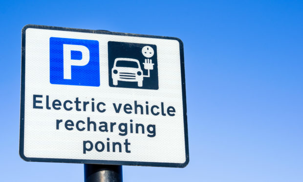 Parking Sign at a Recharging Station for Electric Vehicles and Clear Blue Sky