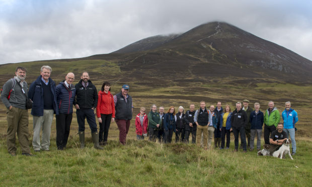 Photo, MSP John Swinney after the ribbon with the Beinn a Ghlo mountain behind
Flanked by Left, Ian Moffett OATS Chair, Outdoor Access for Scotland, & right Doug McAdam, CNPA board Member , with other guests and partners.