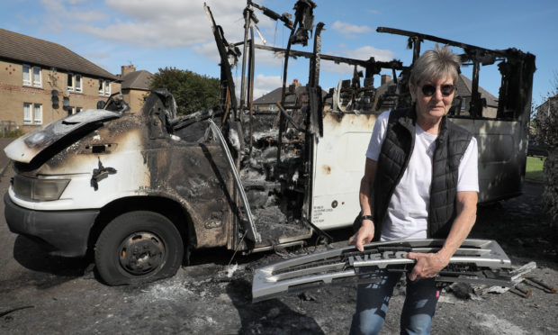 Mary Parry with the burnt out minibus in Methil.