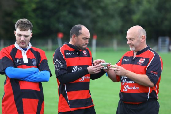 Players take a drink of whisky from the quaich, before the first game on the new Brechin Rugby Club pitch.