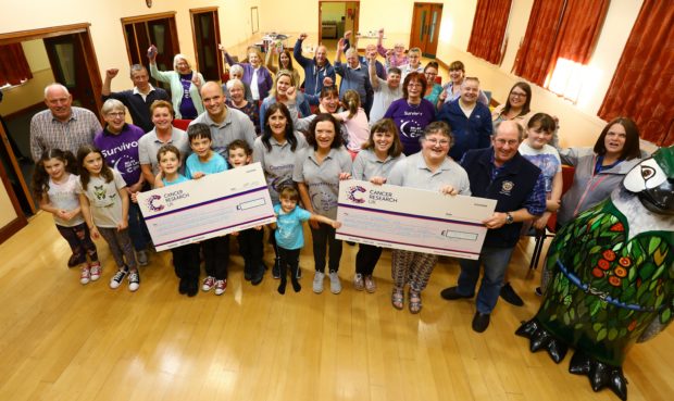 Members of the Kirriemuir CRUK Committee and supporters display the two cheques, one for the amount raised at this years event - £71,727.40, and also the amount raised from the seven Relay For Life events that they have held, totalling £750,725.63.