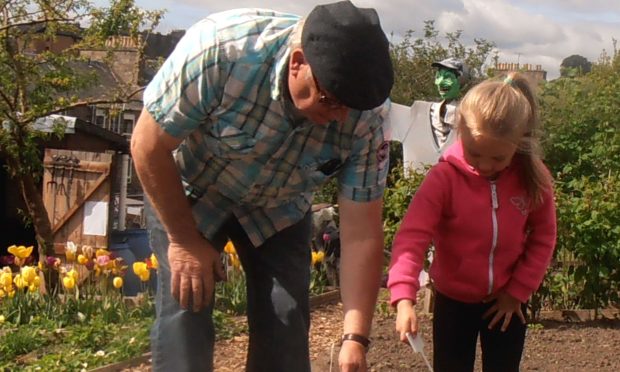 Grandad helping Scarlet plant her pumpkins