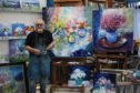 Jolomo with some of his paintings.