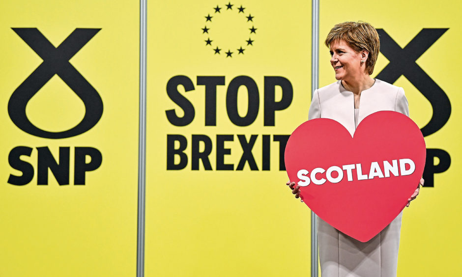 First Minister of Scotland and SNP leader Nicola Sturgeon holds a heart-shaped placard reading "Scotland" at the party autumn conference on October 14, 2019.