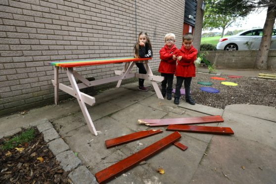 Jessica Craik, Jamie Ritchie and Theo Craik beside the vandalised bench in the sensory garden at Craigiebarns Primary School, Dundee.