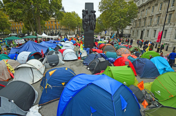 Extinction Rebellion (XR) protesters camp in tents around the Monument to the Women of World War II on Whitehall in Westminster, central London.