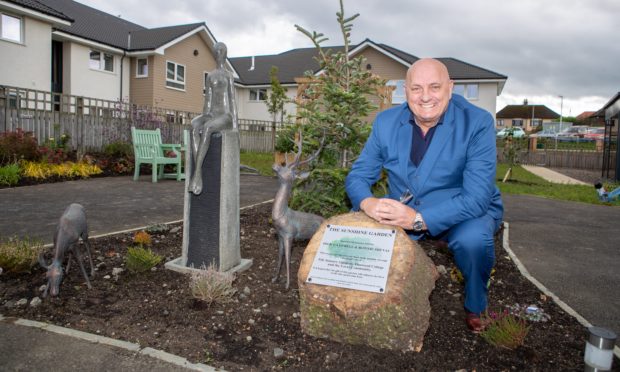 Dick Campbell unveils a plaque commemorating the opening of the garden.