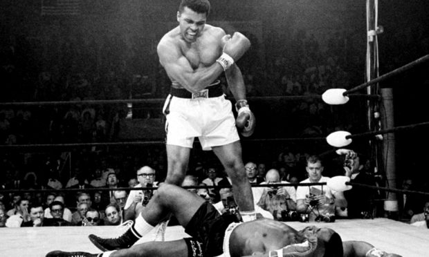 Heavyweight champion Muhammad Ali stands over fallen challenger Sonny Liston, after dropping Liston with a short hard right to the jaw in Lewiston, Maine.