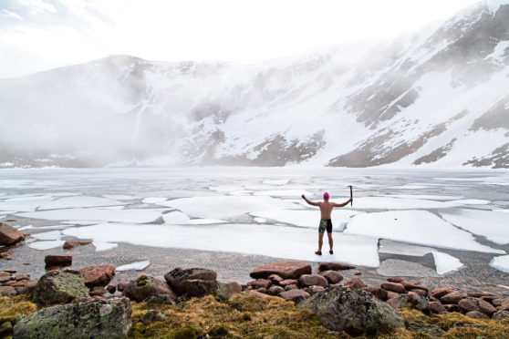 Calum MacLean prepares to swim in ice in Scotland's highest loch.