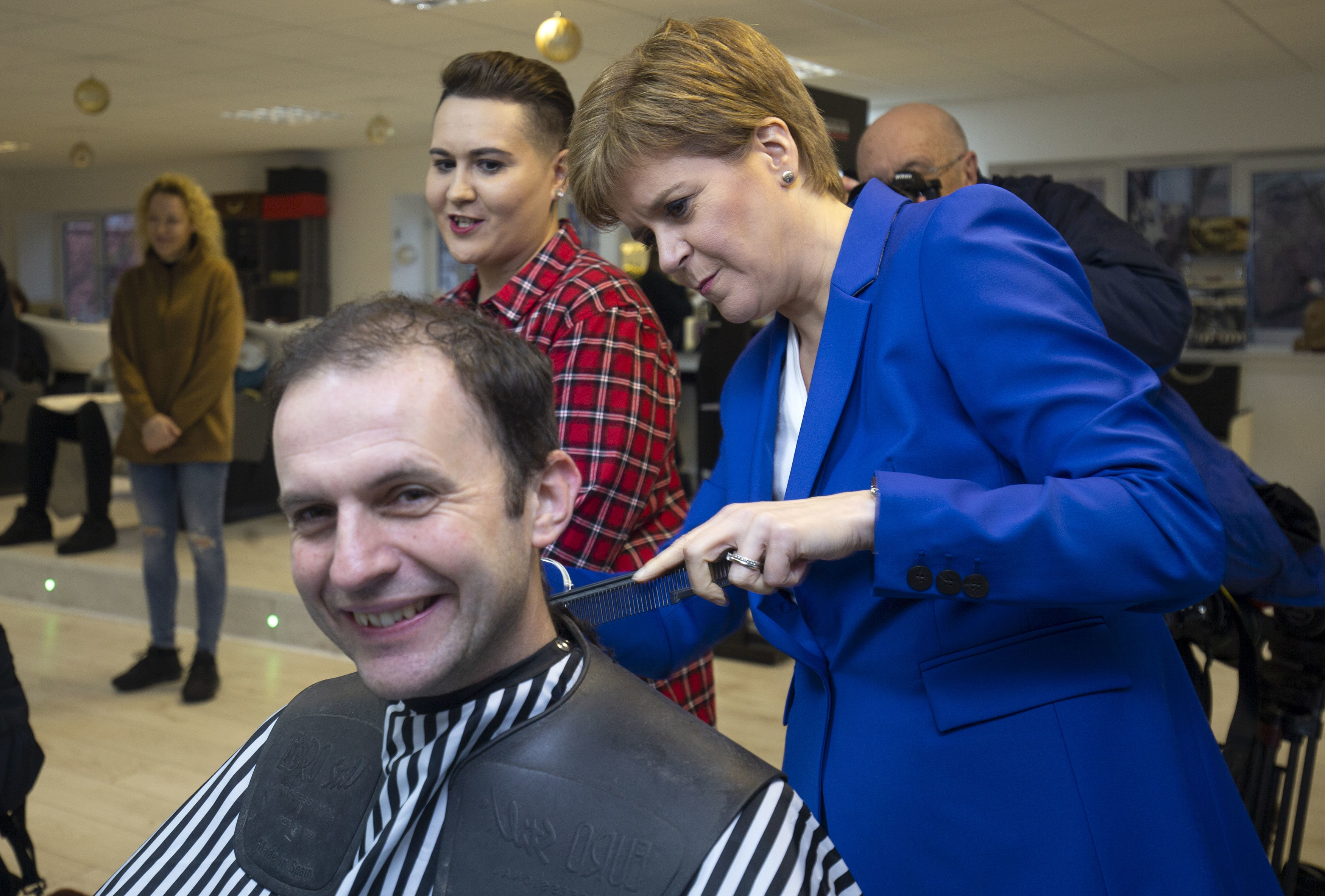 Nicola Sturgeon gives her party's candidate for North East Fife Stephen Gethins a haircut, during a visit to Craig Boyd Hairdressing in Leven, Fife.