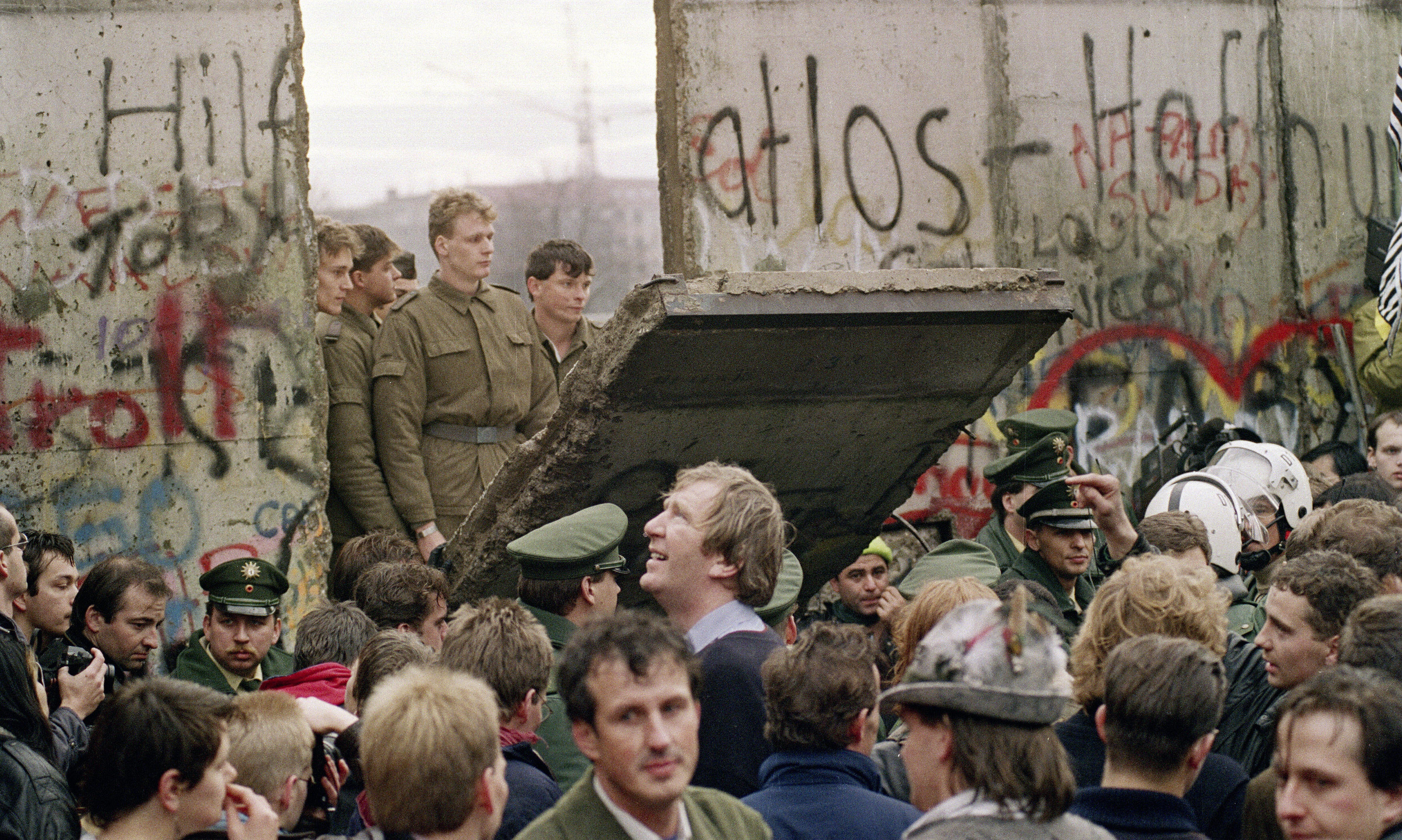 West Berliners crowd in front of the Berlin Wall early November 11 1989 as they watch East German border guards demolishing a section of the wall in order to open a new crossing point between East and West Berlin, near the Potsdamer Square.