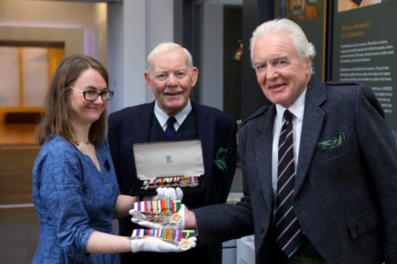 Carly Cooper - McManus curator, with Ian Rae, right, and Sinclair Aitken, centre, Chairman of LACD, holding the medals that were handed over to the McManus Galleries in Dundee in November