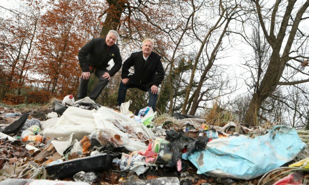 Mr Caldwell, left, and Mr O'Brien inspect some of the rubbish.