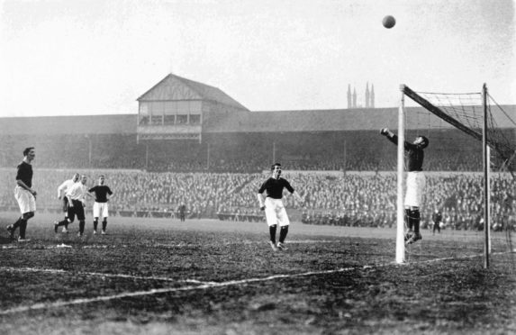 Scotland goalkeeper Ned Doig makes an unorthodox save during an international match.