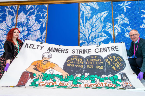 Curators Nicola Wilson and Gavin Grant with one of the mining strike banners ahead of Saturday's conference.