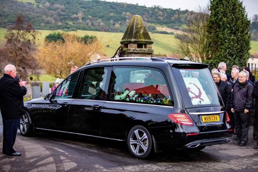 Funeral Director John Gilfillan leads the hearse to the cemetery.