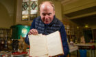 Auctioneer Nick Burns with the book and letter signed by Winston Churchill