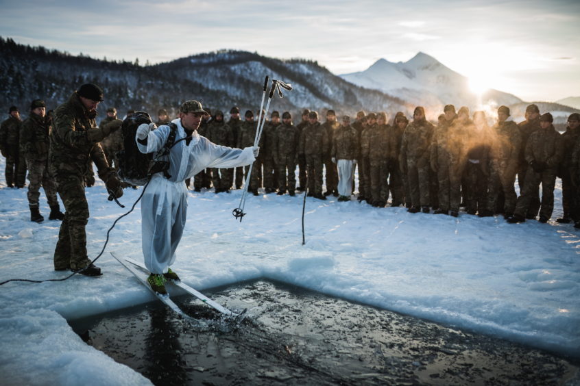 A Royal Marine from 40 Commando about to slide into icy water, during an ice breaking drill in Norway.