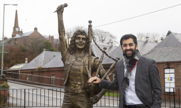 Justice secretary Humza Yousaf at the Bon Scott statue in Kirriemuir.