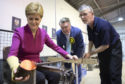 SNP leader Nicola Sturgeon, with SNP candidate for Ochil & South Perthshire, John Nicolson, and glass-maker Calum McDougall (right) makes a glass paperweight at Caithness Glass during a visit to Crieff Visitors Centre