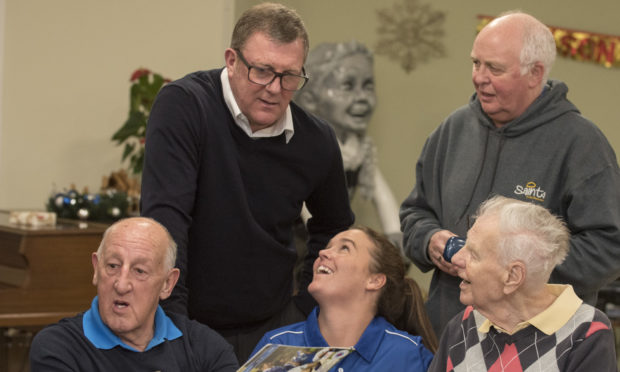 Former St Johnstone Players Visit Perth care Home 
Photo, Pictured at North Inch care Home today seated left , Saints Legend Henry Hall shares a memory with right, Bill walker care home resident & Lynn Melrose , St Johnstone Chef with back  Former players Roddy Grant and right Atholl Henderson, now chief executive of the Saints Community trust team .