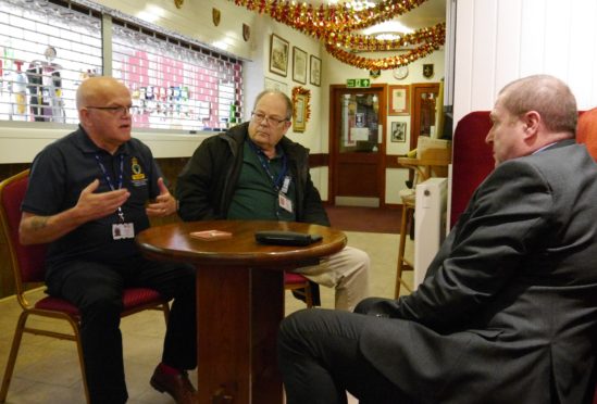 Veterans Minister Graeme Dey meets Legion Scotland volunteers (left to right) Paul Jones and Robert Holland at the Forfar branch of Legion Scotland.  Both are also veterans.