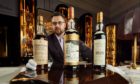 Iain McClune, Whisky Auctioneer founder, with some old bottles. Image: Peter Dibdin Photography
